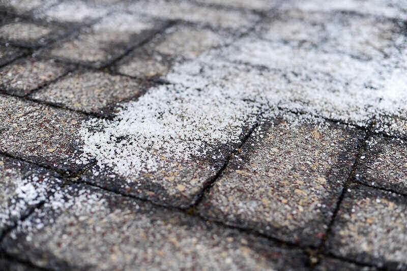 人行道上的盐融化雪的特写