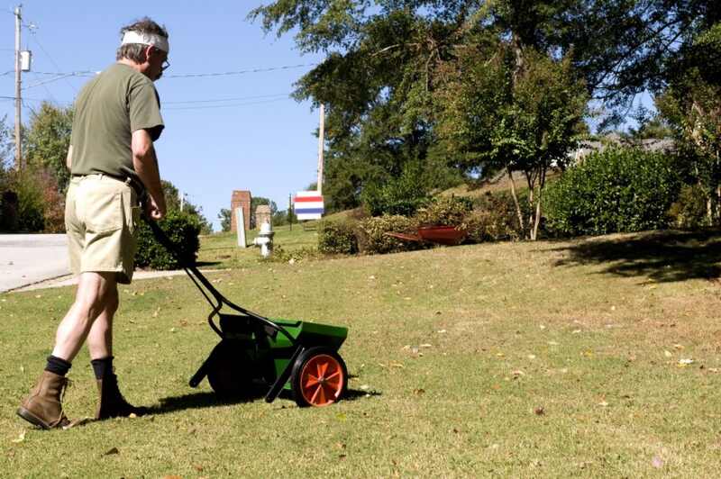 一个男人正在给他的草坪施肥。
