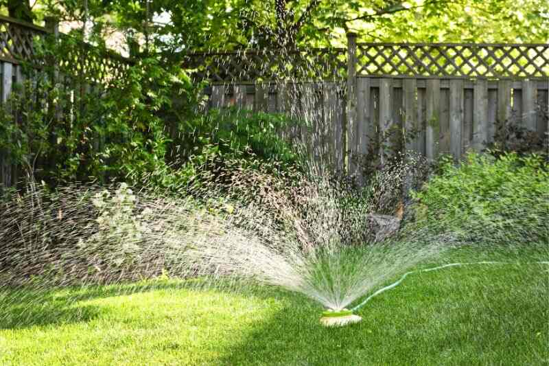 image of a sprinkler system watering the grass